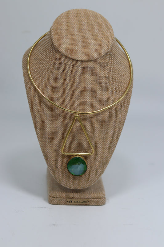 Handmade Kenyan brass choker necklace displayed on a beige burlap bust, featuring a smooth gold-tone collar wire and a geometric triangle drop pendant holding a polished green and blue stone.