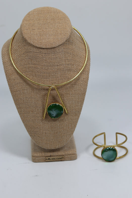 Handmade Kenyan brass choker necklace with a green stone triangle drop displayed alongside a matching open cuff bracelet with a green stone, set on a white background.