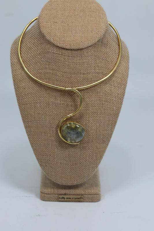 Handmade Kenyan brass collar chocker necklace featuring a sweeping S-curve design and a polished organic stone pendant, displayed on a burlap mannequin.
